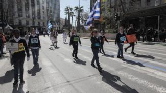 Οι μαθητές του 132ου Δημοτικού Σχολείου Αθήνας ενώ παρελαύνουν κρατώντας μικρές αυτοσχέδιες πικέτες για την ειρήνη